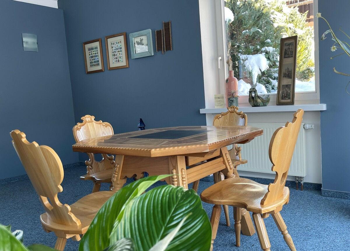 Gartenzimmer mit Holztisch und Stühlen für gesellige Abende.