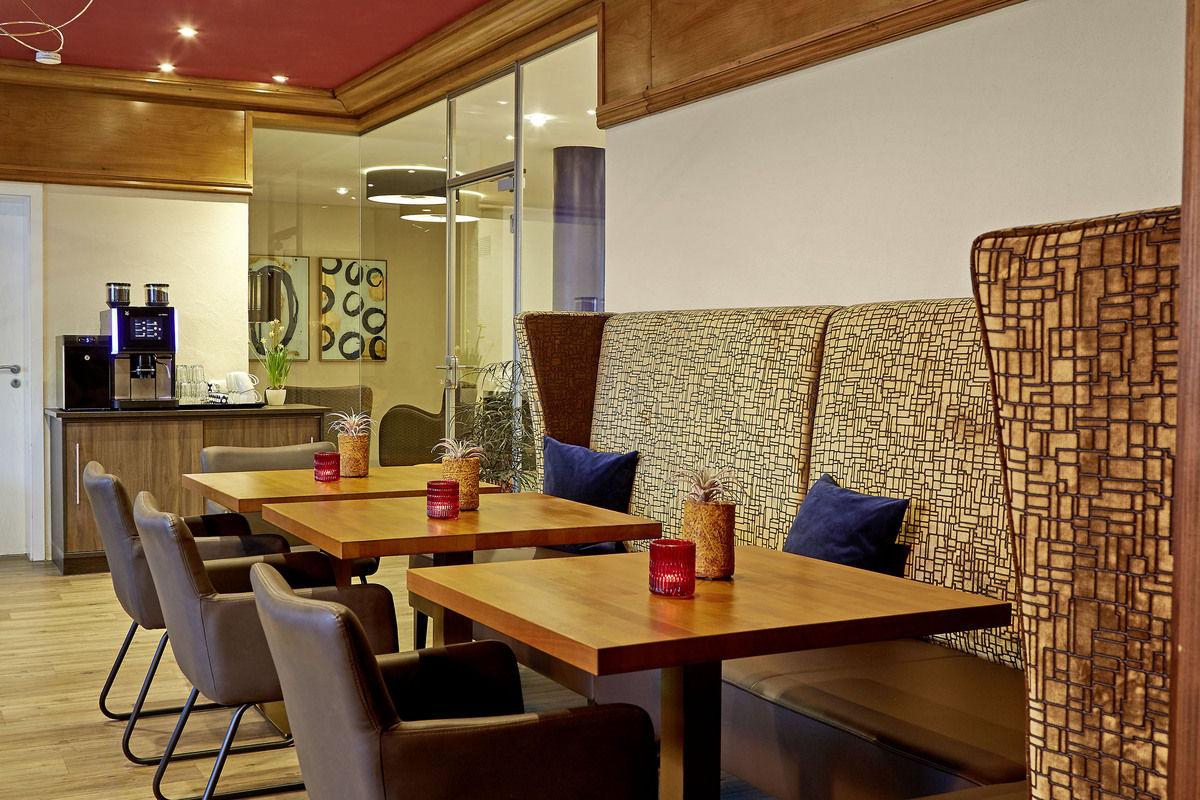 Restaurant mit eingedeckten Tischen und geflochtenem Raumteiler.