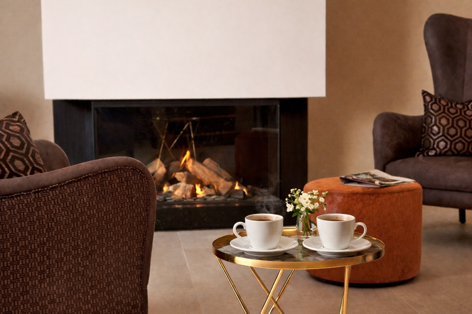 Gemütlicher Sitzbereich mit Kamin und zwei dampfenden Tassen Kaffee auf Tisch.